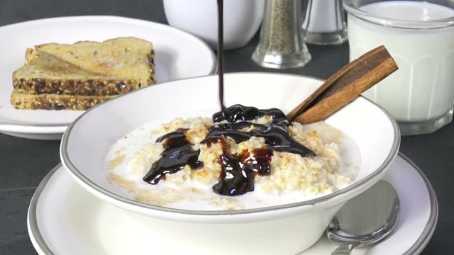 Pouring molasses on a bowl of oatmeal slow motion