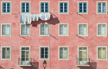 Fototapeta na wymiar Pink facade of european house with simmetrical windows 