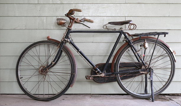 Old Ancient bicycle on the background of a gray wooden wall.