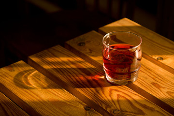 glass with red drink on a wooden table
