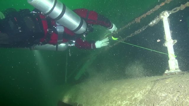 Sidemount tech diver makes secondary tie-off of the line