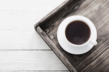 cup of coffee on tray on wooden table