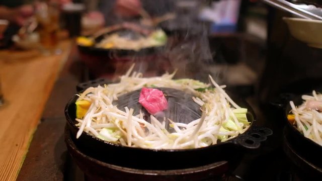 Preparing for Jingsukan (Japanese style grill lamb and vegetables) adding lamb