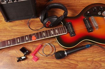 Naklejka premium Electric guitar and musical accessories on a wooden texture