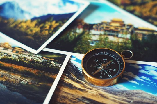 Compass on blur photograph of popular tourist destination background, traveling destination plan concept