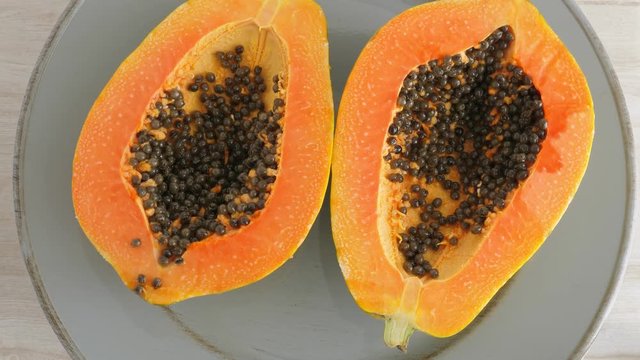 Top view of ripe half cut papaya, flat lay. Rotate