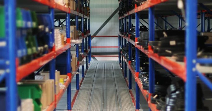 Close-up view of the shelves with industrial and logistics goods inside the large warehouse.
