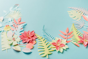 Colorful tropical exotic palm leaves and flowers on blue pastel background, summer, spring, easter, holiday concept, paper art idea