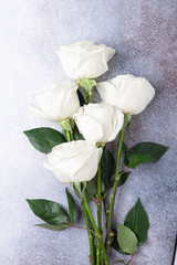 White rose flowers bouquet on light gray stone background