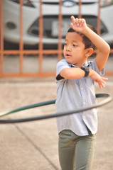 Asean boy and girl set. play hula hoop on the street in town