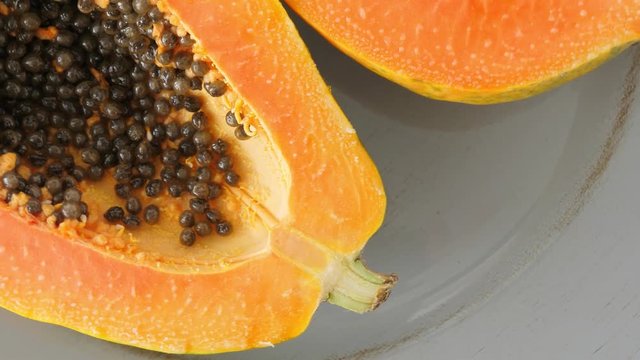 Top view of ripe half cut papaya, flat lay. Rotate
