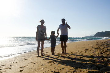 Happy family enjoying on beach. Summer vacation, family with one child having fun on beach