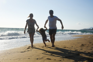 Happy family enjoying on beach. Summer vacation, family with one child having fun on beach