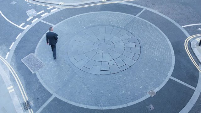Businessman going round in circles themes of the way forward the next step confusion lost