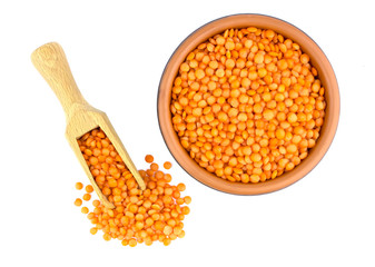 Red lentils in plate and scoop isolated on white background