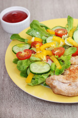 Grilled chicken breast with raw vegetables salad
