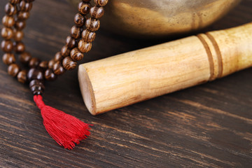 Tibetan singing bowl  with mala beads on dark wooden background with copy space. Essential accessory for mindfulness or meditation.