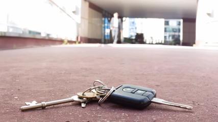 Low angle view of a caucasian businessman picking up lost keys themes of forgotten lost security