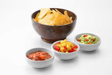 close up view of nice wooden bawl with corn chips  and salsa on white back