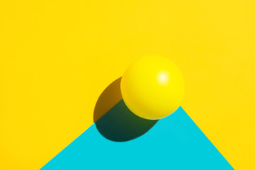 Yellow tennis ball on duotone blue polygon shape element. Abstract colorful graphic geometric composition. Business innovation technology modern arts architecture concept. Creative flat lay copy space