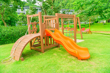 Children kid playground with toy and slider, slides for kids with other in playground, Wooden table and chairs in a garden., Playground in the park.