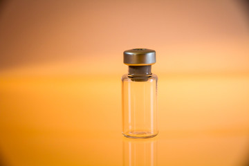 Obraz na płótnie Canvas Vaccine bottle on orange background
