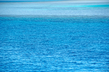 Blue sea with shades of turquoise, azure, emerald colors. Colorful ocean surface