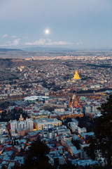 Obraz premium Sunset and evening city Tbilisi, Georgia. Panoramic views and lights of historic neighborhoods.