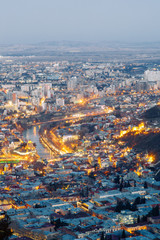 Obraz premium Sunset and evening city Tbilisi, Georgia. Panoramic views and lights of historic neighborhoods.