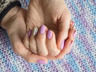 Fashionable lilac manicure design in the hand.