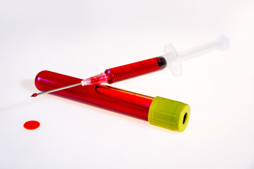 Syringe and tube with blood on white background