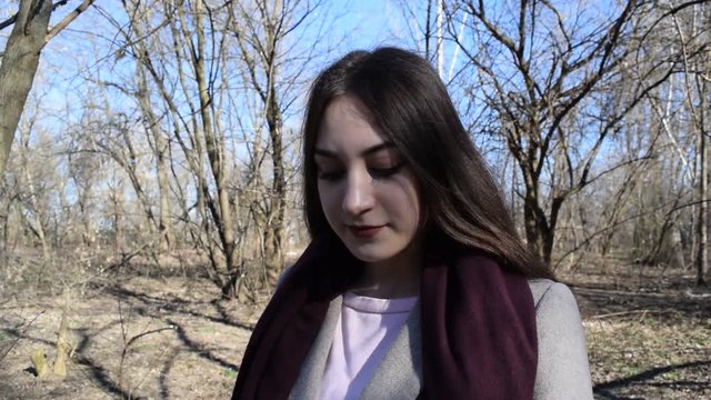 Fashion portrait of a young brunette girl in a dry spring Park.