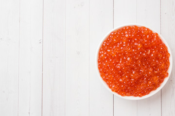 red salmon caviar in a plate on a white table. Copy space