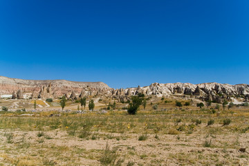 Fototapeta na wymiar Fantastic landscape of Turkish Cappadocia and riders on horseback in the distance.