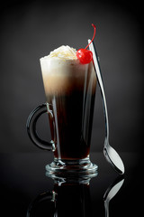 Layered coffee cocktail with whipped cream.