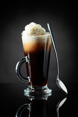 Layered coffee cocktail with whipped cream.