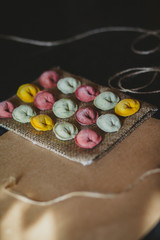 Ravioli of red, yellow and green color on eco rustic fabric