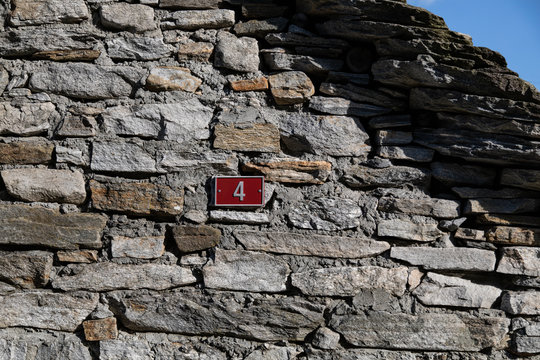 Rustikale Hauswand mit Hausnummer Vier