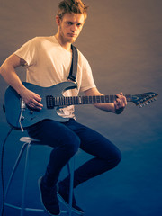 Young man playing electric guitar