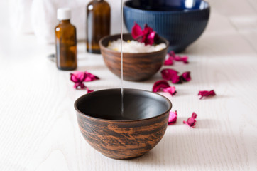 Obraz na płótnie Canvas Pouring cosmetic oil for massage therapy at spa calon, closeup