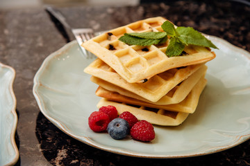 Belgian waffle dessert with chocolate, raspberries, blueberries and mint. Food photo, breakfast