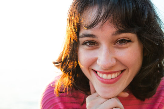 Portrait of a smiling young woman at sunset