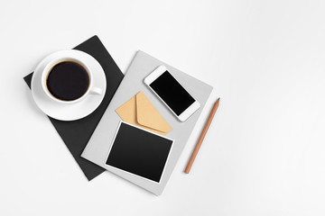 Smartphone and coffee cup, notepad close up top view