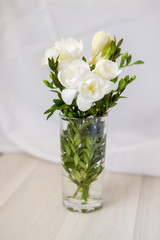 white freesia flowers in a glass