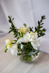 Naklejka na ściany i meble white freesia flowers in a round vase