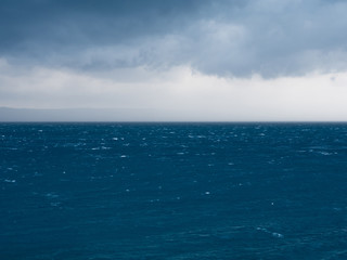 Strong wind and rainy clouds over blue sea
