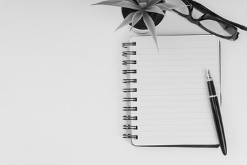 Pen, spectacles, decoration flower and book.Copy Space, Black and White concept.