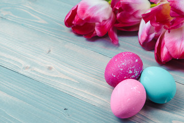 Easter eggs with tulips on blue wooden background