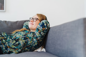 Happy young woman sitting daydreaming