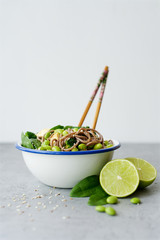 Vegan noodles with green vegetables and tofu Broccoli vegetables, edamame beans, spinach and sesame seeds